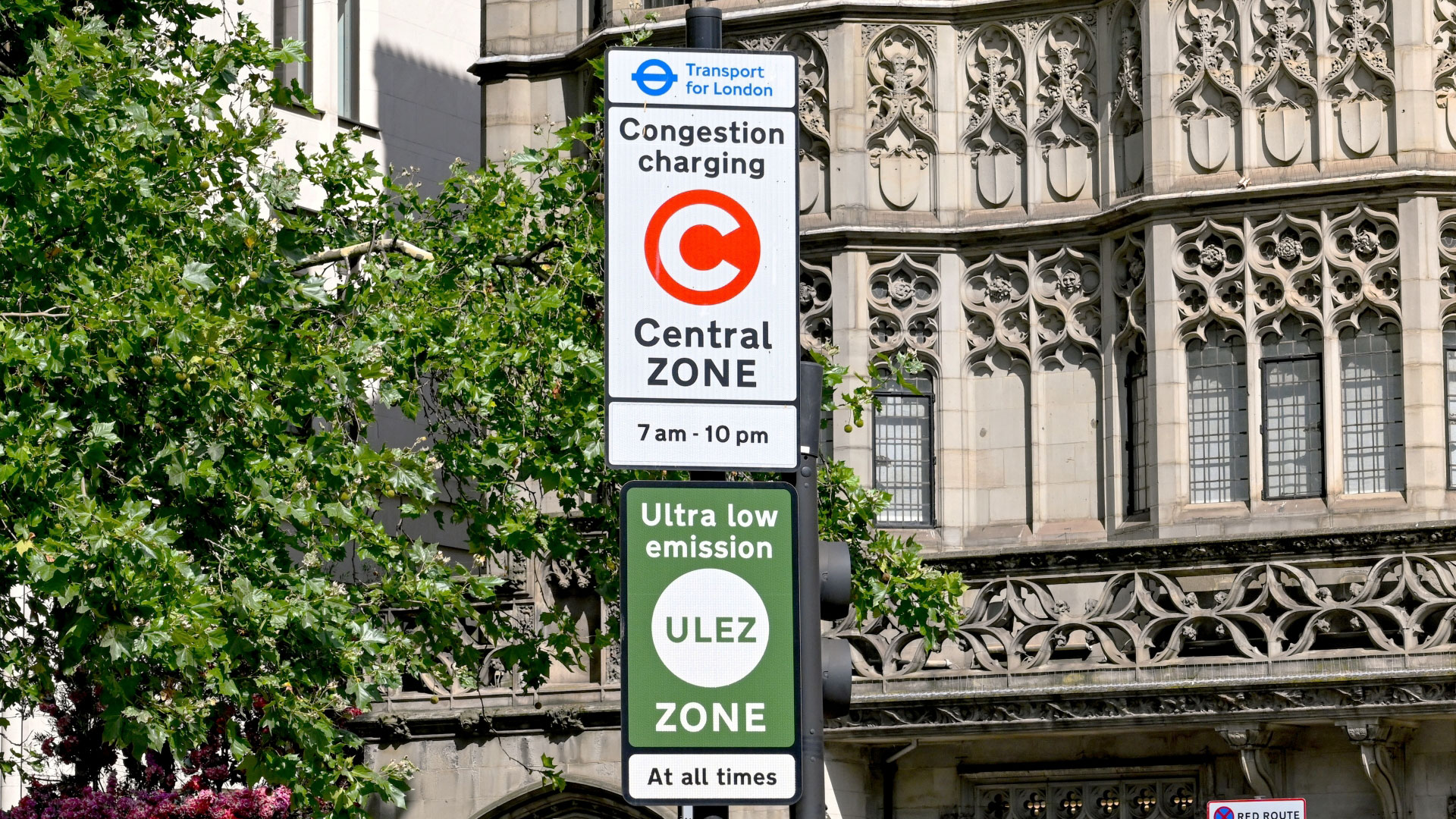 A photo of two road signs showing details of congestion charge and ULEZ zone