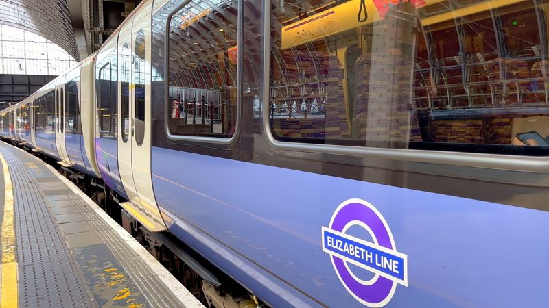 Use the Elizabeth line to travel through London quickly and efficiently. Credit: Shutterstock. Image courtesy of Shutterstock. A photo of the side of a purple Elizabeth line train on a platform with the roundel on the side