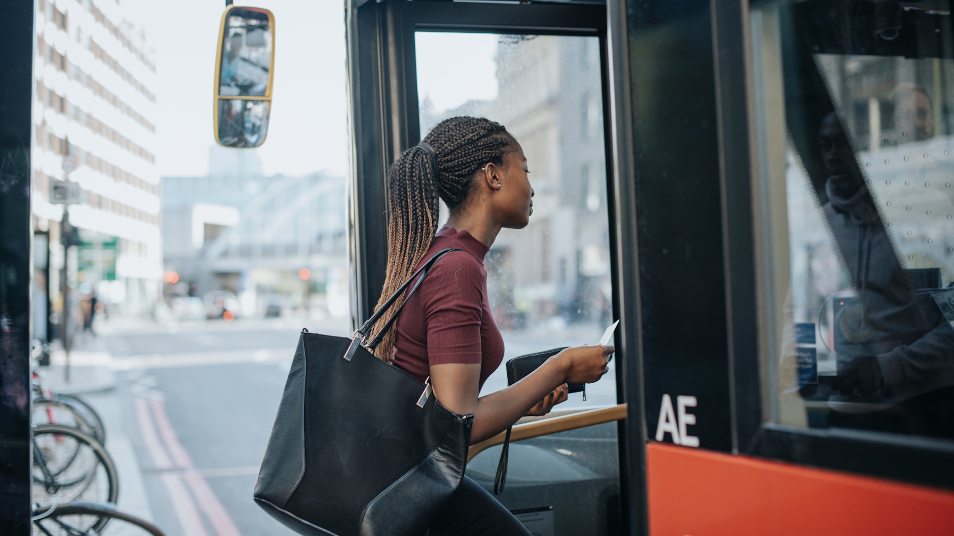 Young black woman boarding a London bus.