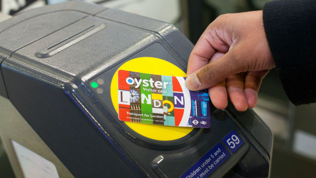 Ein Passagier verwendet eine bunte Visitor Oyster Card an einer U-Bahn Schranke in London. 