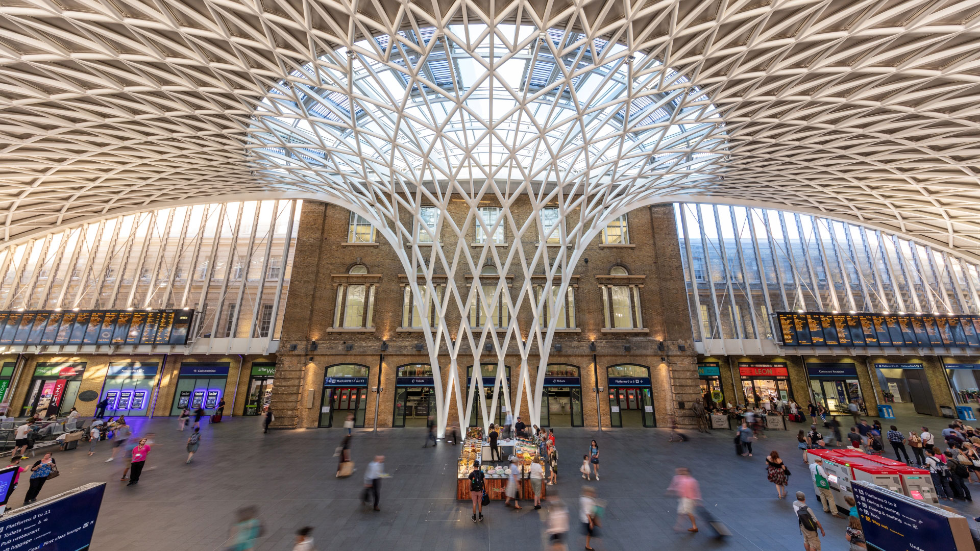 A photo of the Western Concourse at King's Cross Station with people walking around and into shops and eateries
