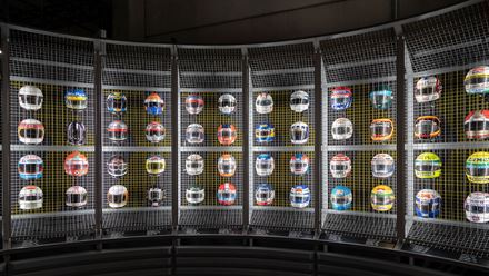See a colourful wall of Formula 1 helmets on display © The Formula 1 Exhibition. Image courtesy of The Formula 1 Exhibition.