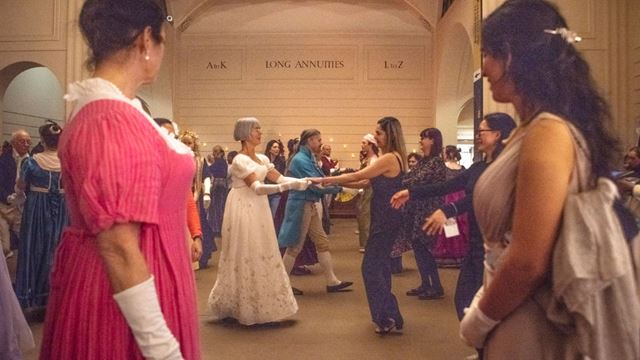 The Austen Ball held at the Bank of England Museum where multiple people are dressed in evening gowns and dancing.