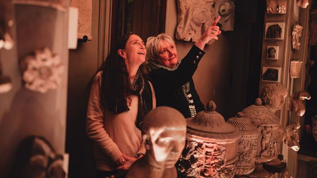Two people looking and pointing up at objects at Sir John Soane’s Museum.