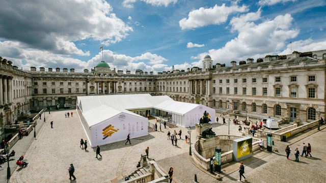 The courtyard at Somerset House, with a marquee in the centre and people milling around the courtyard.