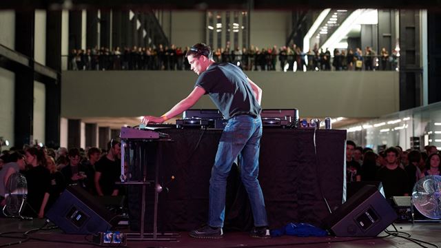 Person behind a DJ deck performing in the Turbine Hall at Tate Modern.