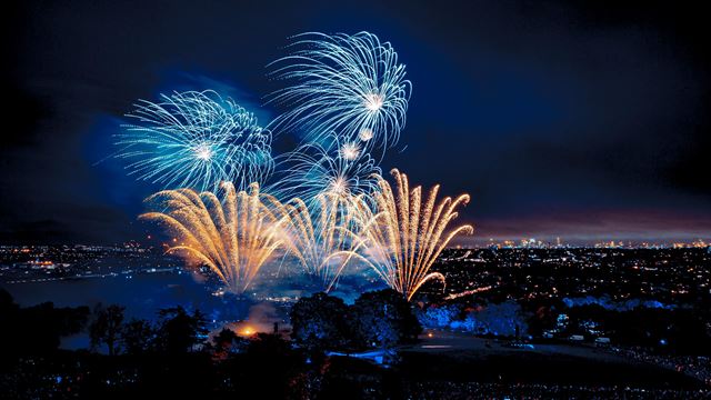 Des feux d'artifices de couleur bleu et or illuminent le ciel londonien pendant la nuit célébrant Guy Fawkes.