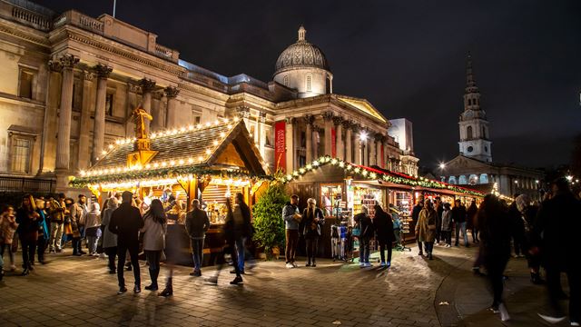 A Christmas market and its chalets are lit up in Trafalgar Square and set up in front of the National Gallery.