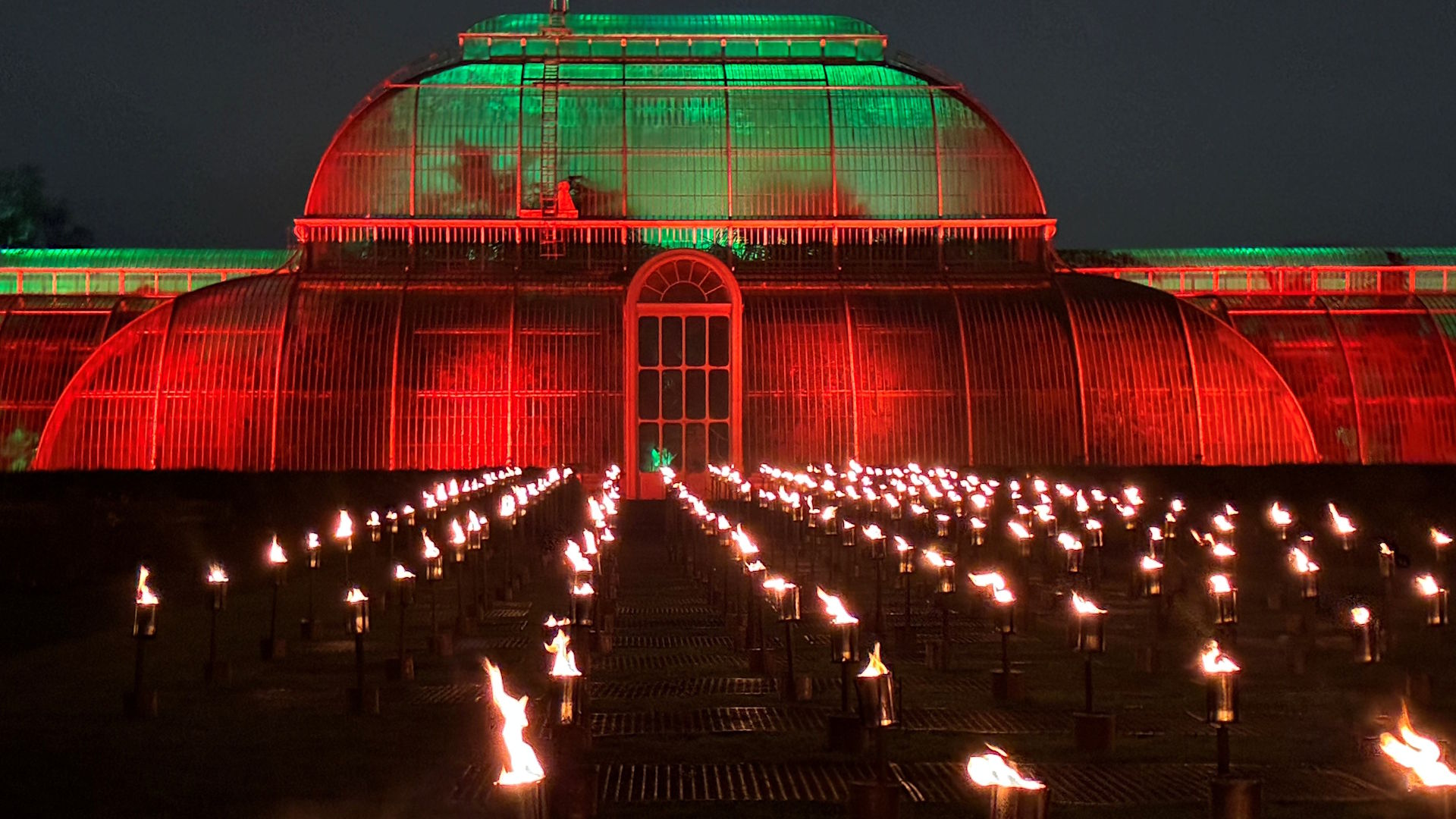 Hundreds of flames flicker in front of the Palm House at Kew Gardens at night, as part of Christmas at Kew.