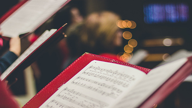 Vue sur une partition de musique couverte d'une reliure rouge.