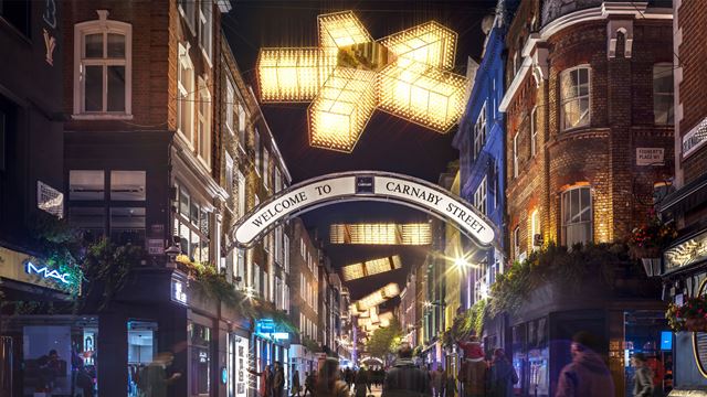 Des visiteurs marchent le long de Carnaby Street admirant les installations lumineuses pendant les fêtes de Noël.