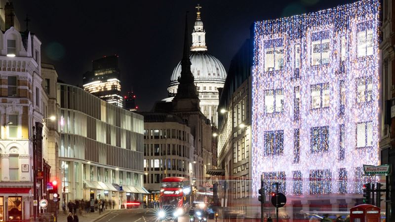 Take photos of St. Paul's Cathedral among Christmas lights at Ludgate Hill. Credit: Fleet Street Quarter. Image courtesy of Fleet Street Quarter. A photo of Ludgate Hill at night during winter with a building front covered in twinkling Christmas lights, St. Paul's Cathedral in the background lit up and red buses and cars on the street in the foreground