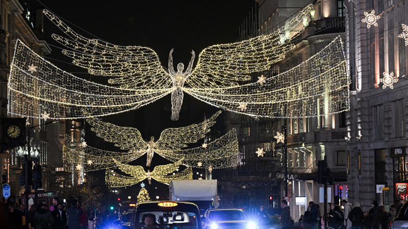 Visit the iconic Christmas film locations dotted around London. Credit: Jack Hall/PA Media Assignments. Image courtesy of Regent Street. A photo of the iconic Regent Street angels at night made up of lots of white Christmas lights hung above the road from buildings on either side with black taxis and cars below