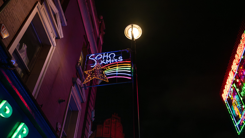 Don't miss the Soho Kids Xmas Lights that bring festive cheer to the district of Soho this Christmas. Credit: London Metropolitan University/Westminster Council. Image courtesy of Architecture for Kids. A rectangular panel of Christmas lights hang over Soho in the night sky with a shooting star in rainbow colours and the words