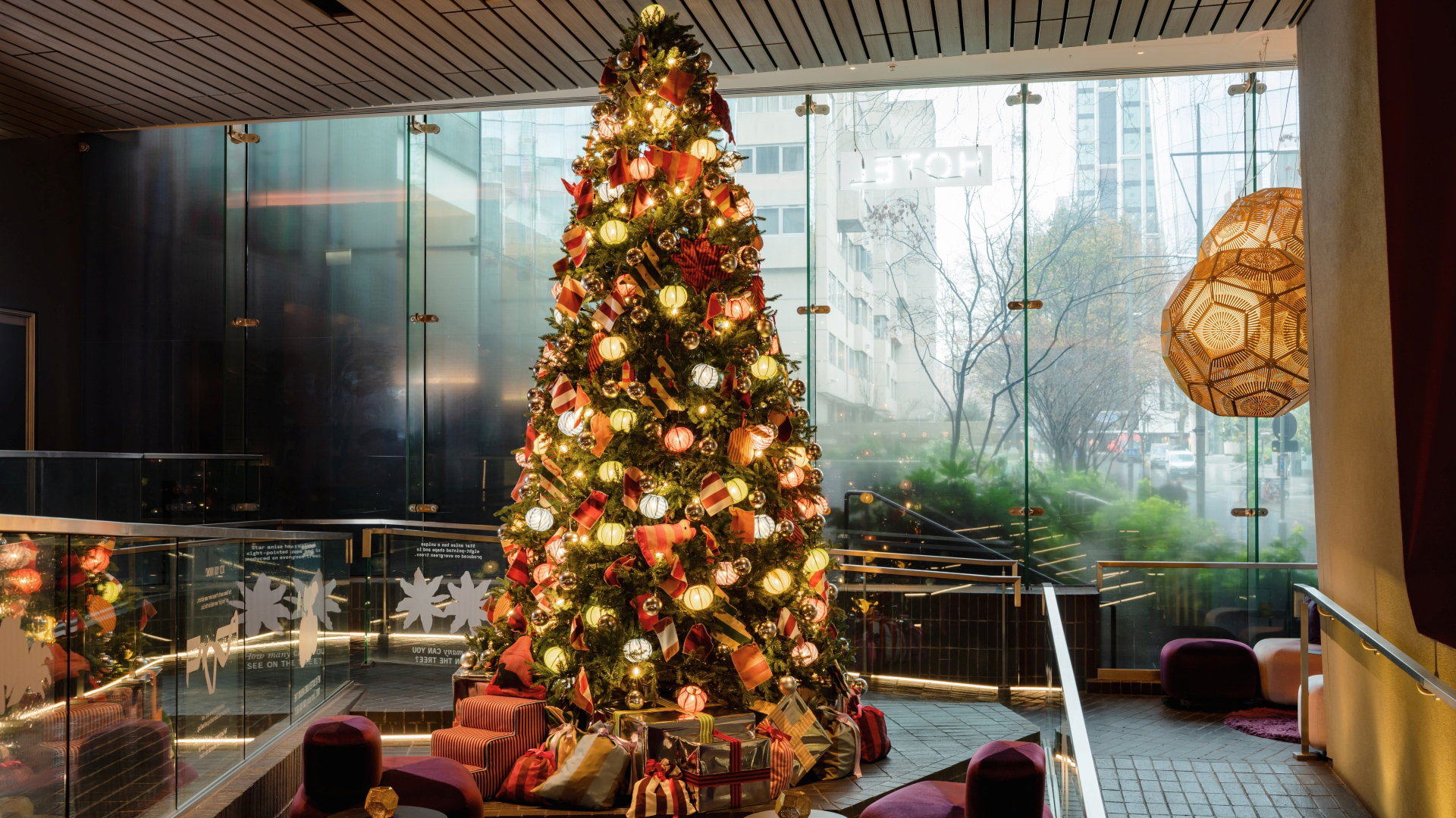 A photo of the Christmas tree at Sea Containers covered in baubles and decorations made form textiles, stood in the hotel foyer