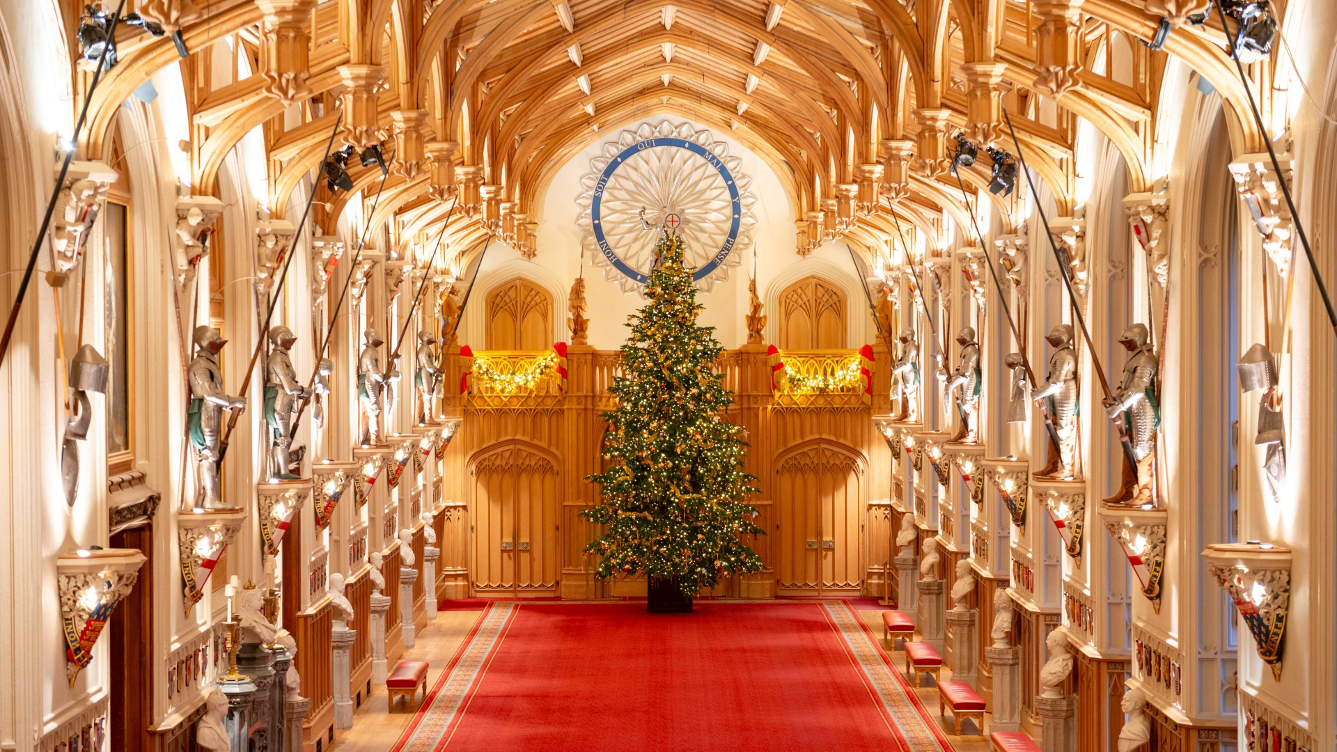 A photo of the large Christmas tree on display in St George's Hall at Windsor Castle, covered in traditional gold decorations
