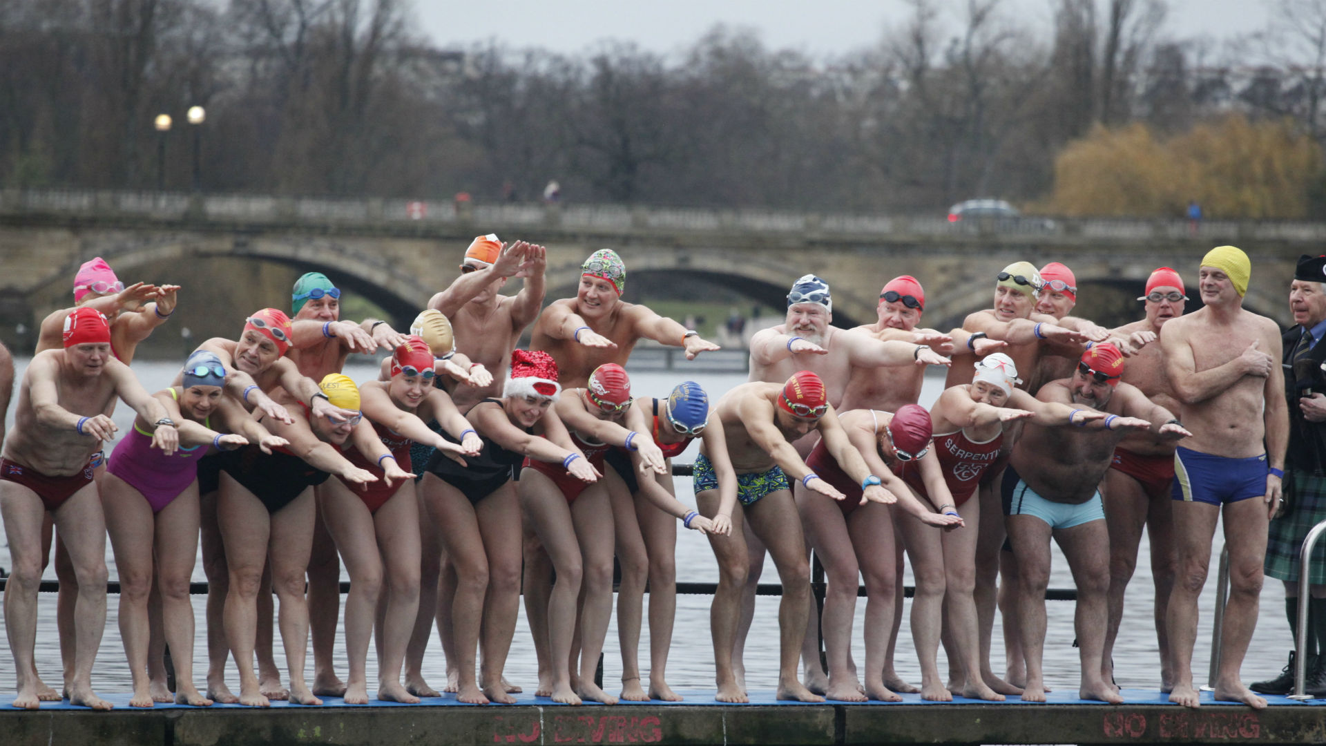 People in their swimming costumes about to jump into the water during The Christmas Day Peter Pan Cup in Hyde Park. 