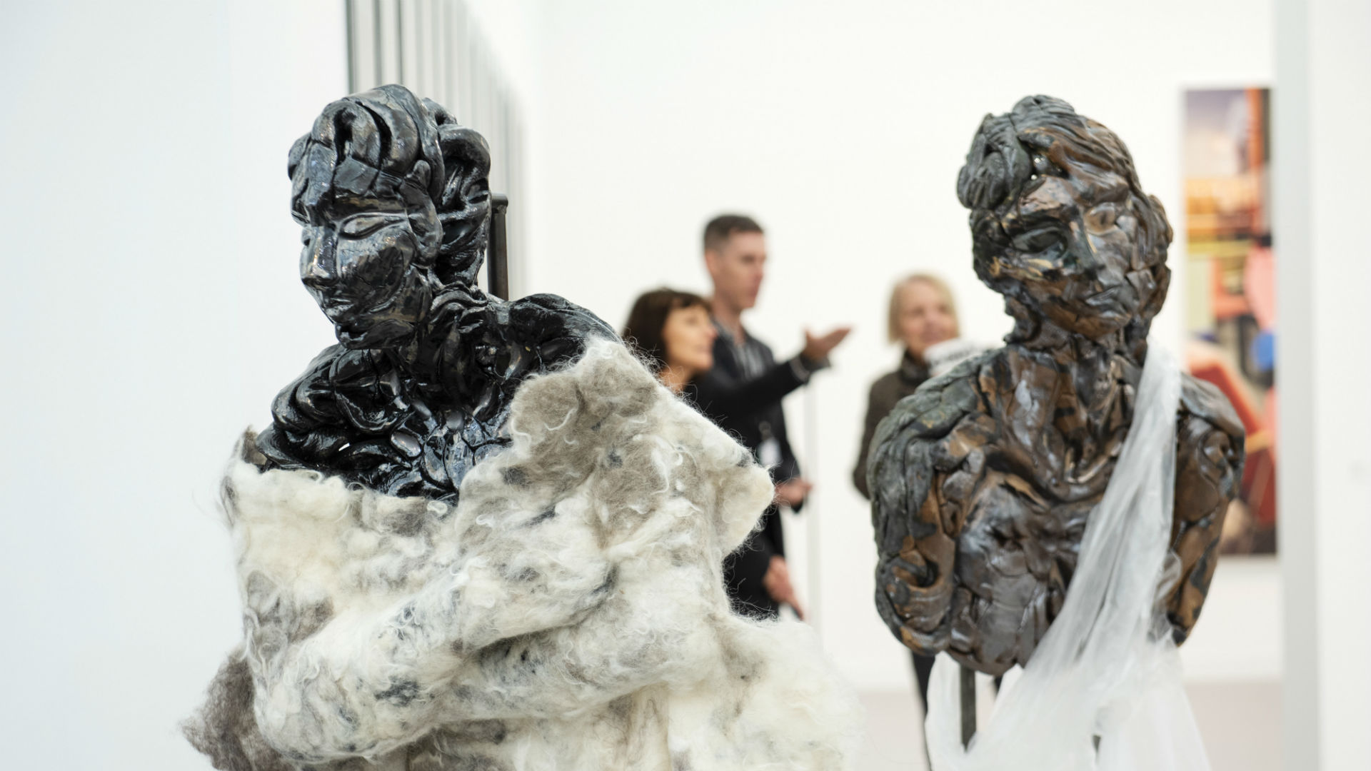 Two bronze human-like sculptures clothed in white fabric at Frieze Art Fair 2018.