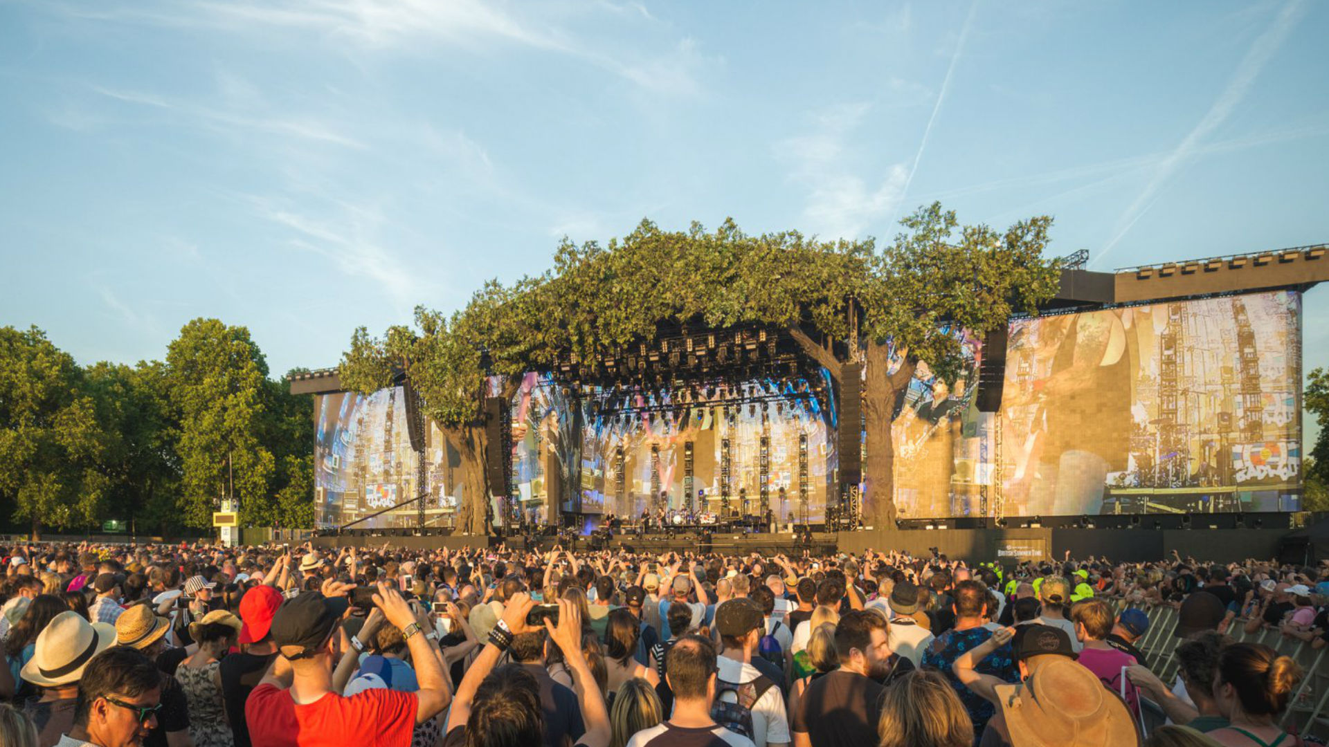 British Summer Time im Hyde Park. Bild mit freundlicher Genehmigung der Outside Organisation. Bildnachweis: Tom Hancock. Eine Menschenmenge beobachtet einen Künstler auf der Bühne unter sommerlichem Himmel.