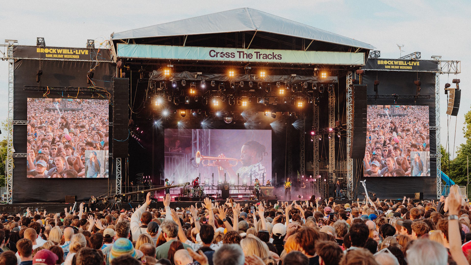 A daytime view of the stage at Cross The Tracks with festival-goers in the foreground.
