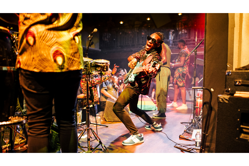 Jam out with world-class musicians at the intimate Jazz Cafe. Credit: Ben Mcquaide. Image courtesy of Jazz Cafe. Guitarist looks into camera next to rest of band with crowd in the background
