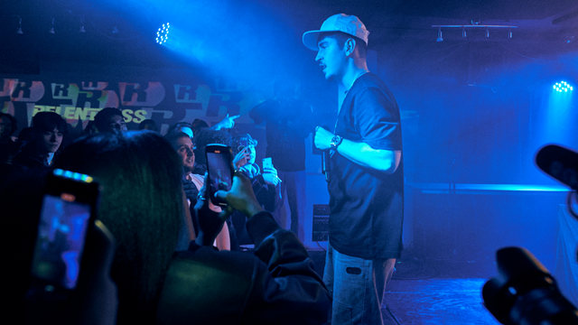 Blue lights illuminate singer on stage at Notting Hill Arts Club as crowd watches