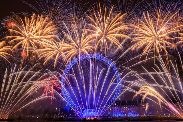 Feu d'artifice coloré de la Saint-Sylvestre au-dessus du London Eye illuminé de lumières bleues.