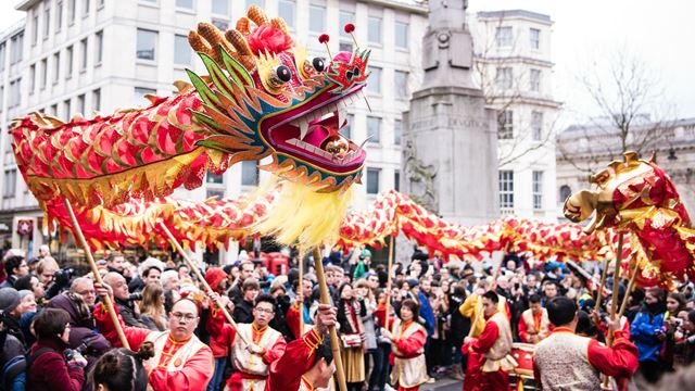 Red dragon dancers surrounded by onlookers at the Chinese New Year parade in London