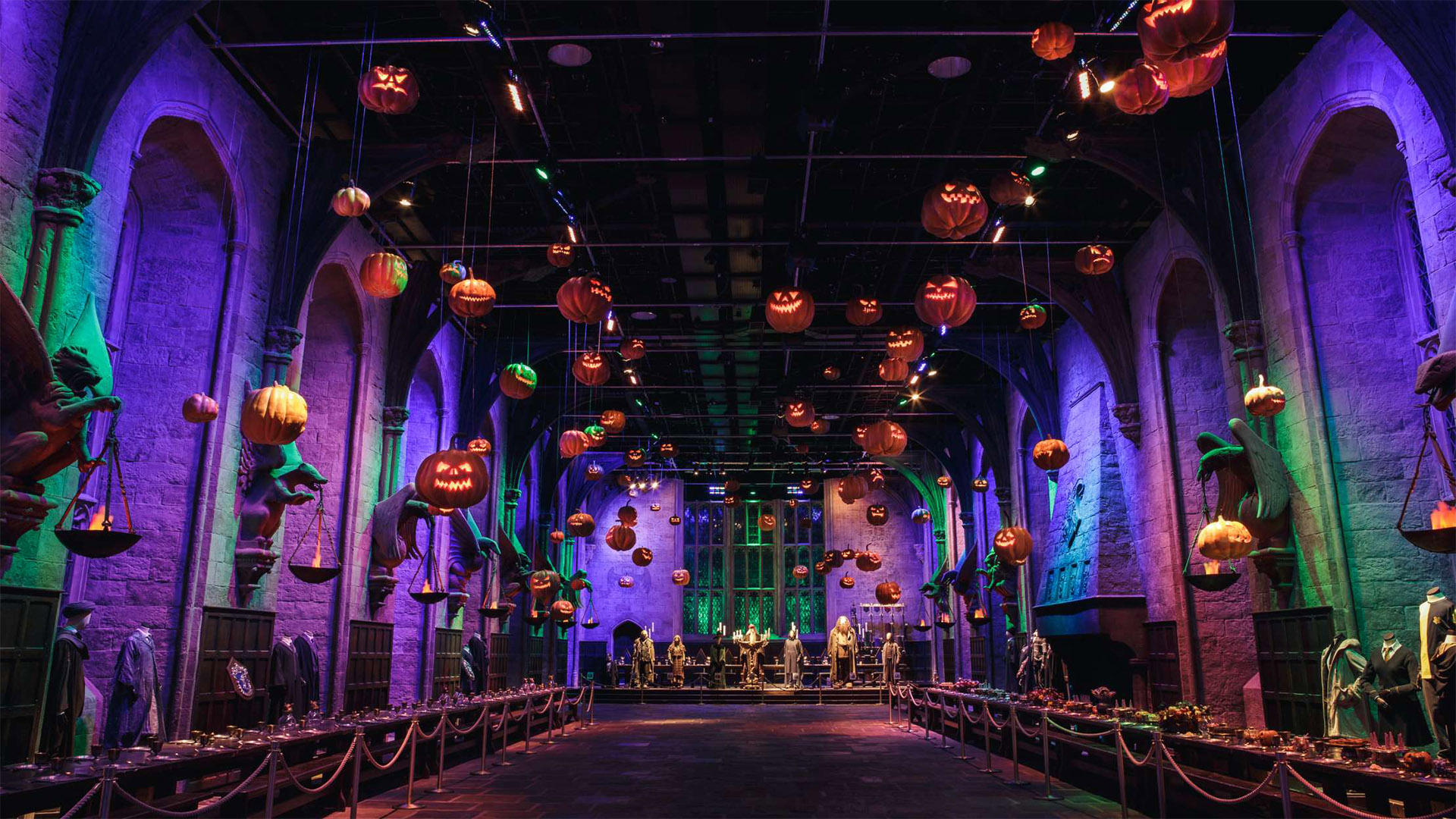 Explorez Poudlard pendant Halloween lors d'une visite des studios Warner Bros. de Londres. Image fournie par Fever PR. La Grande Salle de Poudlard est décorée de citrouilles flottantes et de lumières violettes tamisant les murs.