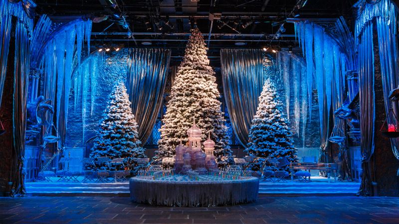 Great Hall with Yule Ball stage at Hogwarts in the Snow. TM & © Warner Bros. Entertainment Inc. Harry Potter Publishing Rights © JKR. Image courtesy of Fever PR. Christmas tree on Great Hall with Yule Ball stage at Hogwarts in the Snow at Warner Bros. Studios the Making of Harry Potter