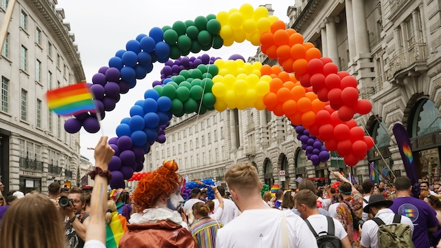 Feiern Sie Pride in den Straßen von London zur jährlichen Pride Parade. © life.of.siobhan. Regenbogenfarbene Luftballons schweben während der Pride Parade über einer Menschenmenge in London.