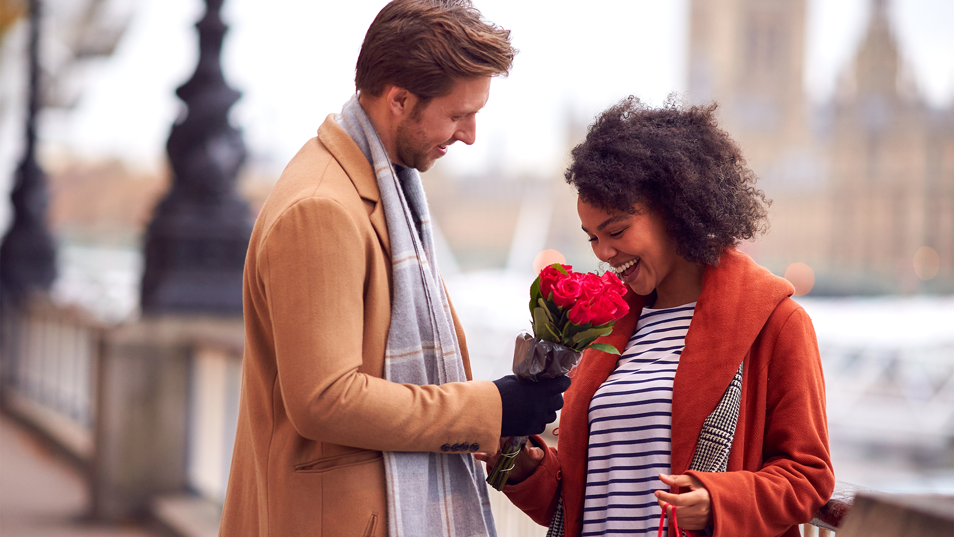A man gives flowers to a woman outside of the Houses of Parliament in London on Valentine's Day.