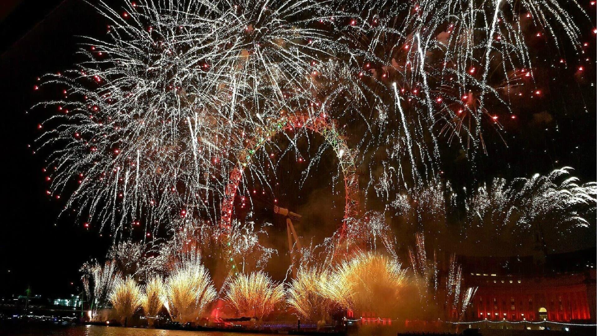 Gold and red fireworks around the Coca-Cola London Eye on New Year's Eve.