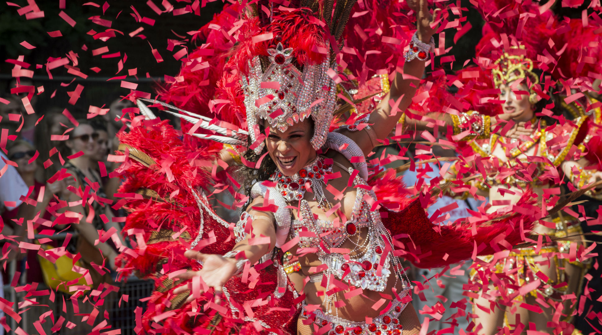 Photos.London / Natasha108 / iStock Eine Darstellerin des Notting Hill Carnival tanzt, während sie von Konfetti umgeben ist