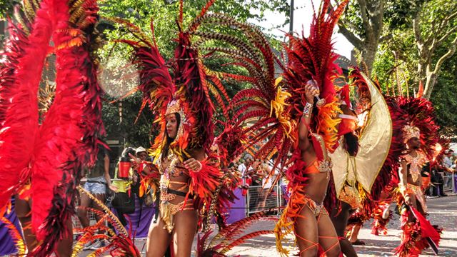 A photo of performers enjoying the Notting Hill Carnival 2016, dressed in red costumes. 