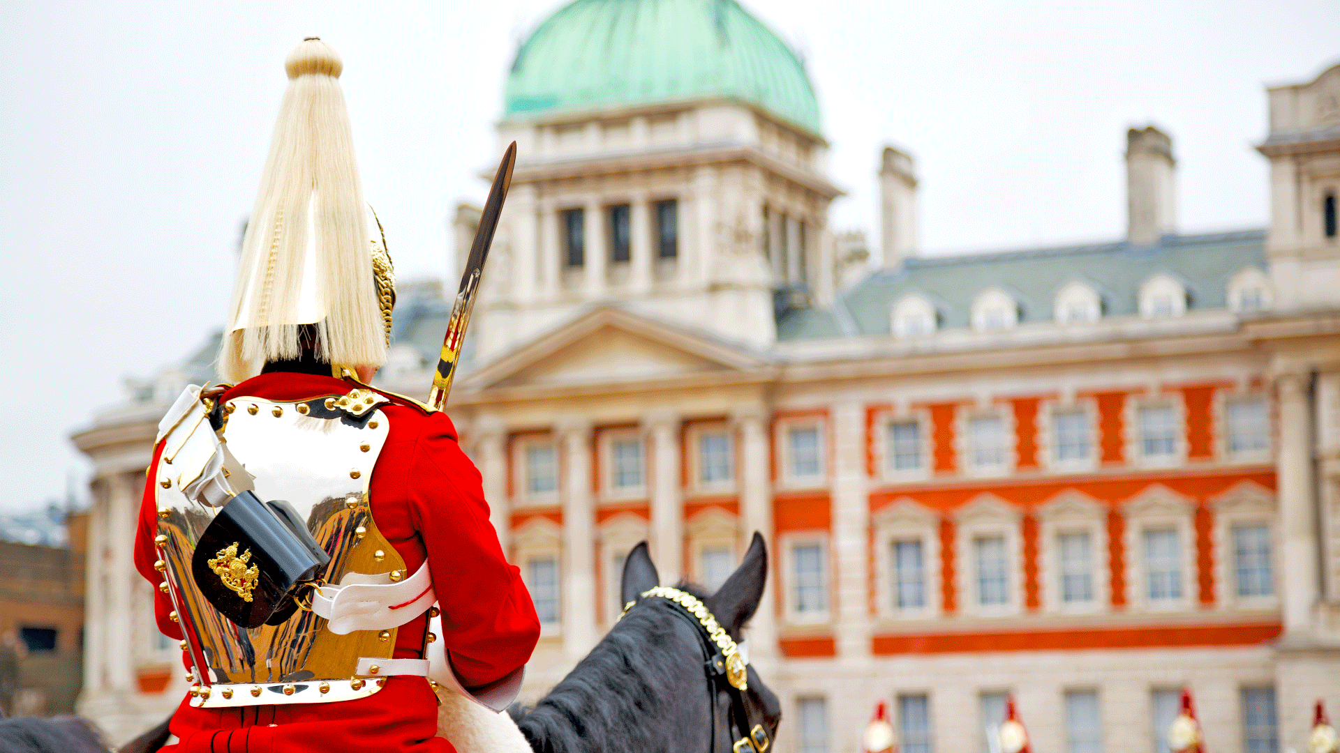 Horseguard sits on top of black horse in front of the Horseguards Parade