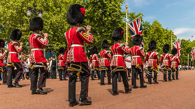 Trooping the Colour © Shutterstock Die in rote Tuniken und schwarze Bärenfellmützen gekleideten Wachen marschieren mit ihren Instrumenten die Mall entlang in Richtung Buckingham Palace.