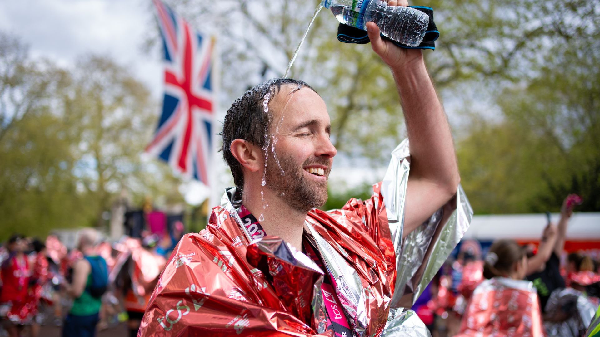 A runner pours water over himself to cool down after completing The TCS London Marathon on Sunday 21st April 2024.