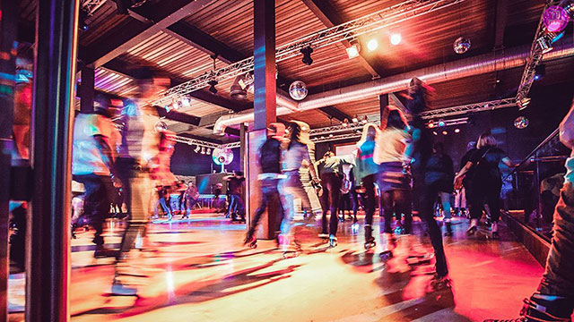 Enjoy a retro-style roller skating disco in London at Roller Nation © Roller Nation. Image courtesy of Roller Nation. People roller skating around the roller disco rink at Roller Nation.