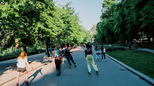 People roller skating in Hyde Park on a sunny day.