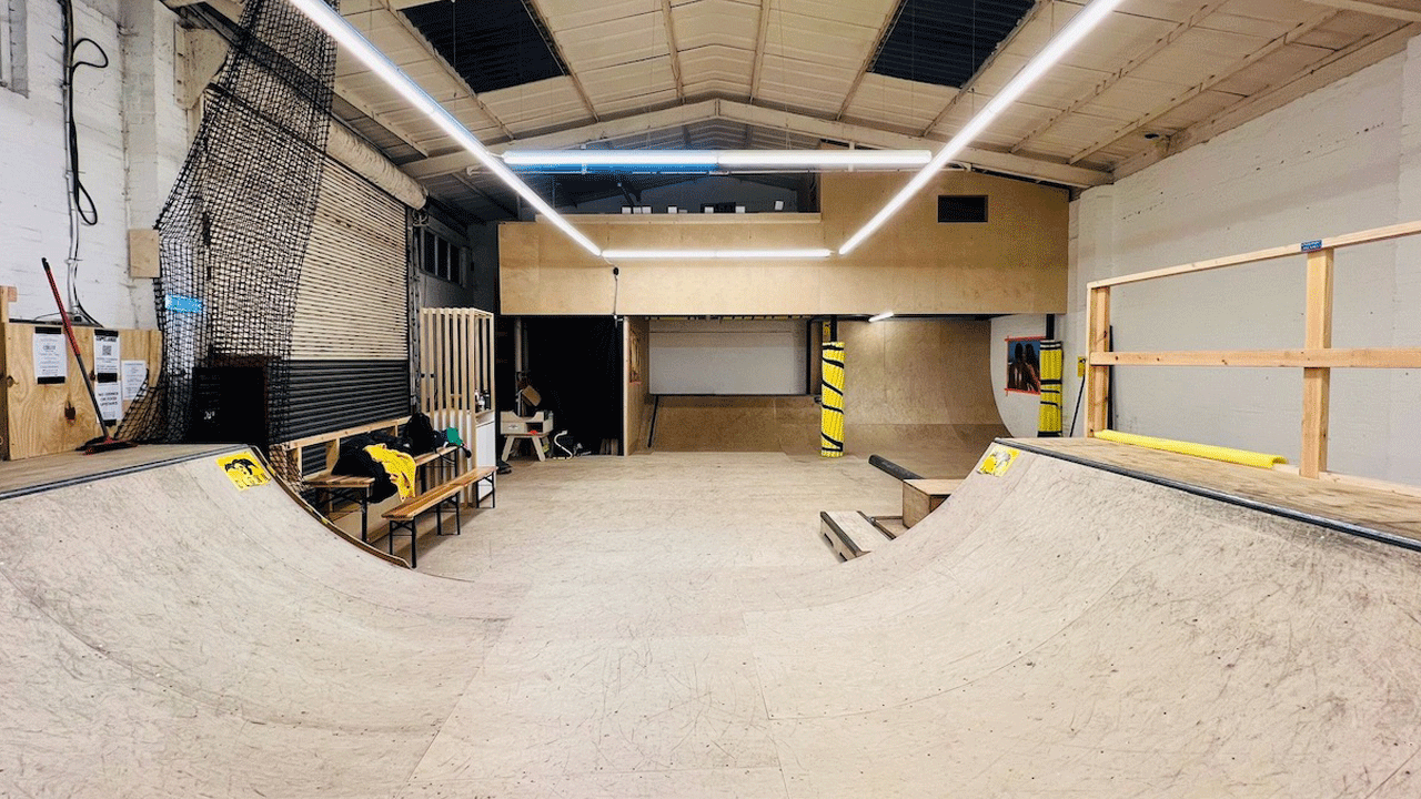 LED lights glow above the ramp at School of Skate skatepark