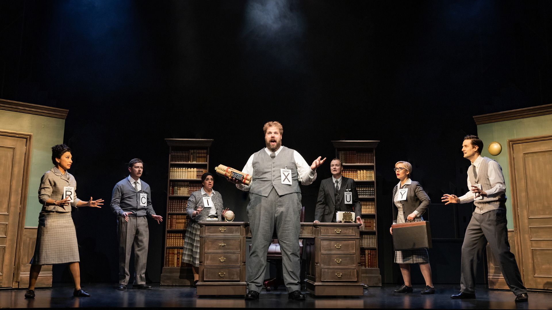 Watch the show that goes off with a bang at The Comedy About Spies. Image courtesy of London Theatre Direct. MI5 agent stand confused on stage at The Comedy About Spies