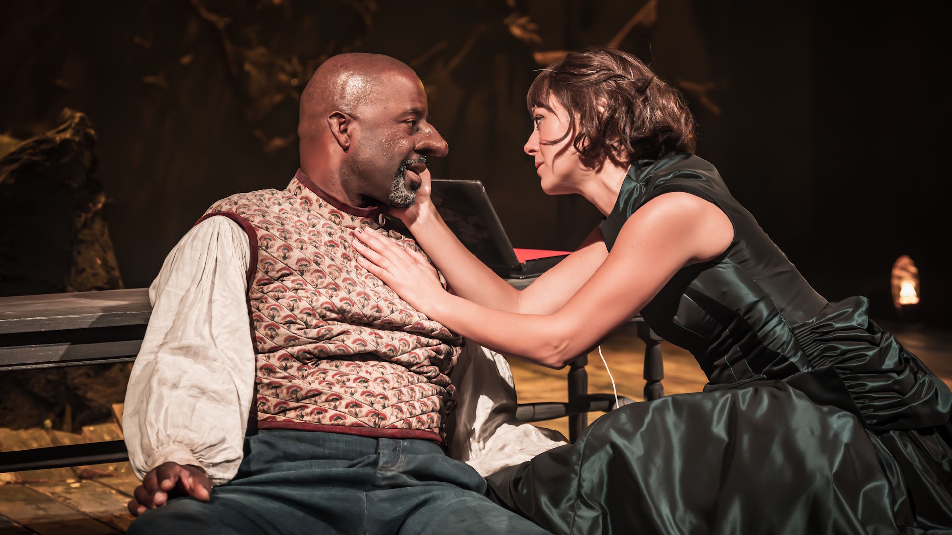 Adrian Lester and Susannah Fielding gaze at each other while seated during a performance of Cyrano de Bergerac.