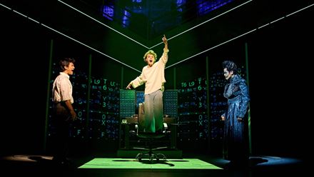 The cast of Death Note: The Musical perform a high-energy scene under colourful stage lighting. Image courtesy of London Theatre Direct.