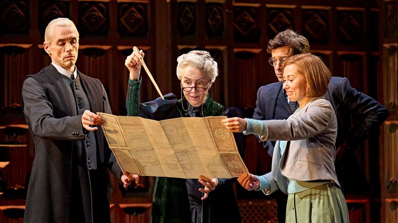 See wizardry at its finest at London's Palace Theatre this season as wizards, spells and the dark arts make a comeback in Harry Potter and the Cursed Child. Image courtesy of London Theatre Direct. The actors playing the Potters and the Malfoys in Harry Potter and the Cursed Child are holding a map trying to figure out some sort of problem.