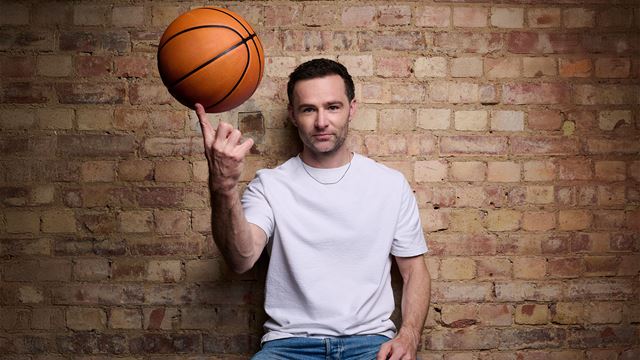 In a promotional shot of his casting as Coach Bolton in High School Musical, Harry Judd is pictured sitting with a basketball rolling on his finger.