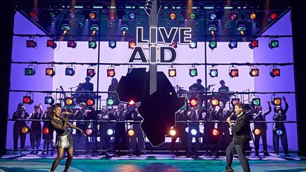 Discover the story of Live Aid, the concert that rocked the world in 1985, in the new musical Just For One Day. Image courtesy of Dewynters/Photos from the production of 2024 at the Old Vic.