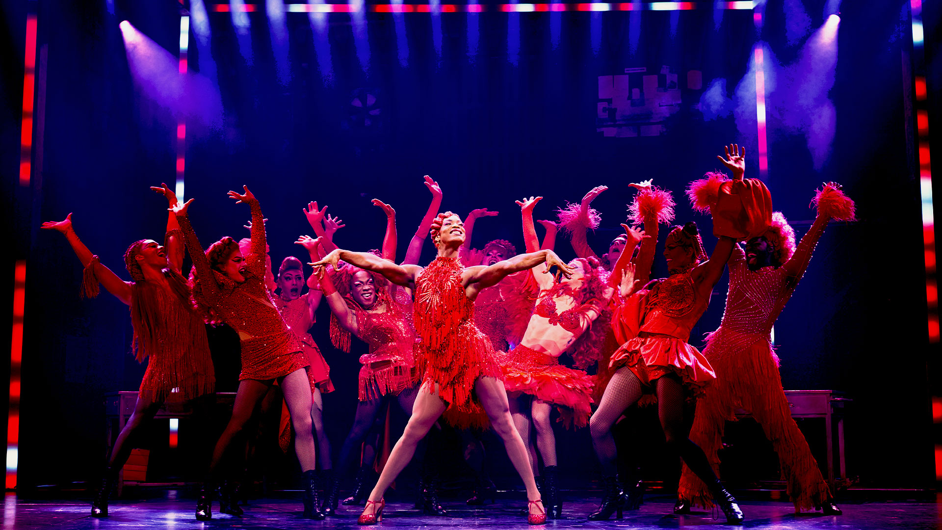 Watch the revival of Kinky Boots, starring Strictly Come Dancing's Johannes Radebe as drag queen Lola. Photo credit: Matt Crockett. Dressed in a red, sparkly dress, Johannes Radebe dances on the Coliseum stage alongside the ensemble cast, who are dressed as the Angels, Lola's fellow drag queen performers.