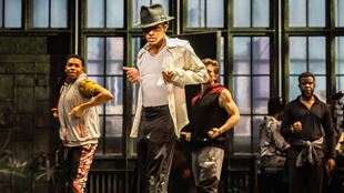 Vêtu d'un chapeau noir, d'une chemise blanche et d'un pantalon noir, Myles Frost répète une chorégraphie avec son équipe lors d'une représentation de MJ the Musical.