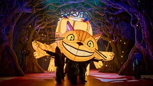 The giant inflatable yellow Cat Bus flies onto the stage, leaving a forested landscape behind it.